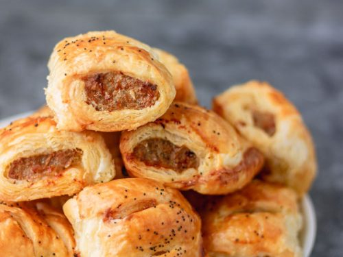 stack of mini sausage rolls in a white plate.